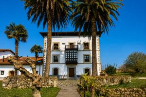 a house with palm trees in front of it at Tejasturias |Piscina, Pádel y Playa de La Franca in Noriega