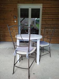 a table and two chairs sitting on a porch at le chardonneret in Commer