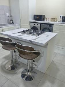 a kitchen with a stove and two bar stools at Sydney's Guest House in Johannesburg +9 photos