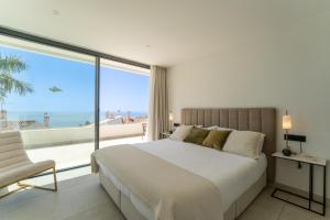 a bedroom with a large bed and a large window at Sea Gardens Villa in Nerja +34 photos