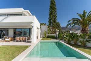 a villa with a swimming pool in front of a house at Sea Gardens Villa in Nerja