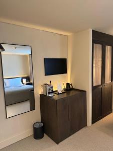 a room with a bedroom with a mirror and a dresser at Hyll Hotel in Chipping Campden