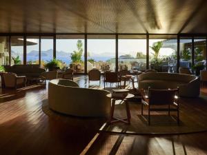a restaurant with chairs and tables and windows at Fairmont Rio de Janeiro Copacabana in Rio de Janeiro