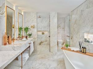 a white bathroom with two sinks and a shower at Fairmont Rio de Janeiro Copacabana in Rio de Janeiro