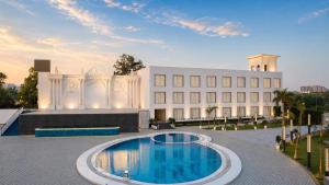 a building with a swimming pool in front of a building at White Wharf Manesar in Gurgaon