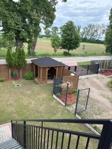 a small woodenshed with a fence in a yard at Domek z basenem in Kodrąb