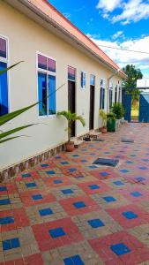 a building with a tiled courtyard in front of it at La casa Motel in Kahama