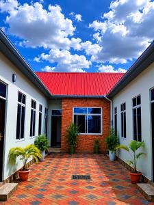 a house with a red roof and a brick courtyard at La casa Motel in Kahama