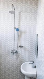 a bathroom with a shower and a toilet and a sink at La casa Motel in Kahama