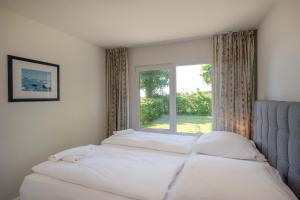 a bedroom with a bed and a window at Boddenweite 1 in Born