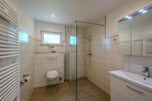 a bathroom with a shower and a toilet and a sink at Boddenweite 1 in Born +15 photos