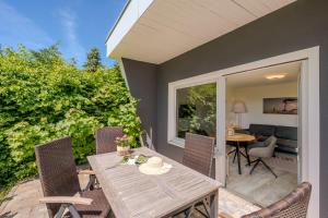 a patio with a wooden table and chairs at Boddenweite 1 in Born