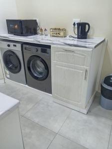 a washer and dryer in a kitchen with a counter at Sydney's Guest House in Johannesburg