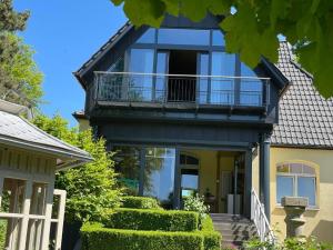 a house with a balcony and stairs in front of it at Villa Stolle, Ferienwohnung in Schneverdingen