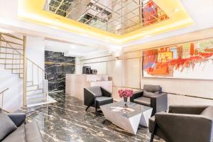 a lobby with chairs and a table and a staircase at Marine Point Hotel & Antalya in Antalya