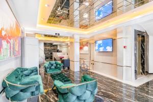 a lobby with green chairs and a television at Marine Point Hotel & Antalya in Antalya