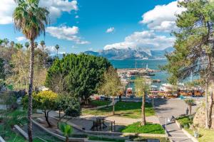a park with a view of the water and mountains at Marine Point Hotel & Antalya in Antalya