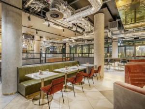 a restaurant with a row of tables and chairs at Novotel Leicester in Leicester