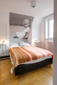 a bedroom with a bed with a painting of a woman at Bonnie's Beachhouse - villa aan zee in De Panne