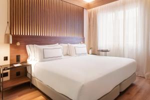 a large white bed in a hotel room at Meliá Granada in Granada