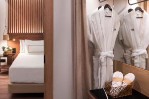 a bedroom with a bed and clothes and shoes at Meliá Granada in Granada