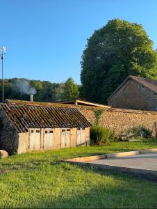 an old brick building on the side of a road at Aux Petits Bourgeons in Adainville