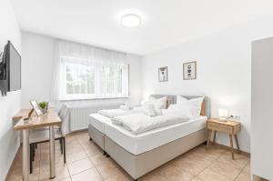 a white bedroom with a large bed and a window at Gasthaus Hirschkeller in Göppingen