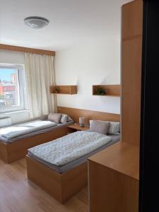 a hotel room with two beds and a window at Penzion U Tomáše in Ratíškovice