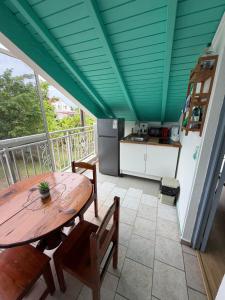 a kitchen with a wooden table and chairs on a balcony at Le Naturel in Vidon