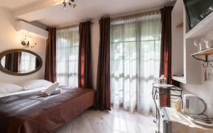 a bedroom with a bed and a large window at Willa Ahava in Kazimierz Dolny +14 photos