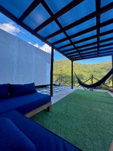 a living room with a couch and a hammock at Chalé loft reserva Refúgio nas Montanhas in Marechal Floriano