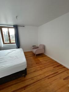 a bedroom with a bed and a chair in it at Appartement Villars Colmars in Villars-Colmars