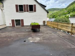 a white house with a wooden fence next to it at Ferienhaus zum Wasserfall in Bernkastel-Kues