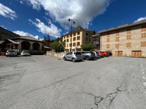 a parking lot with cars parked in front of a building at Appartement Villars Colmars in Villars-Colmars