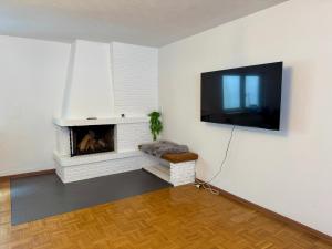 a living room with a fireplace and a flat screen tv at Ferienhaus zum Wasserfall in Bernkastel-Kues