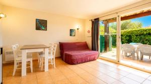 a living room with a table and a couch at Samaria Village N08 - 2P4 in Agde
