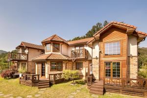 a large house with a deck on a yard at bonghwa solbaram pensyeon in Bonghwa