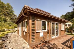 a small wooden cabin with windows on a deck at bonghwa solbaram pensyeon in Bonghwa +6 photos