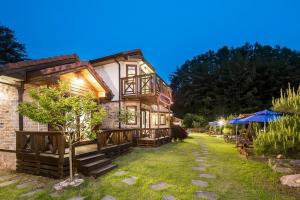 a large wooden house with a lawn in front of it at bonghwa solbaram pensyeon in Bonghwa