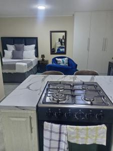a kitchen with a stove and a room with a bed at Sydney's Guest House in Johannesburg
