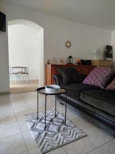 a living room with a couch and a table at le chardonneret in Commer
