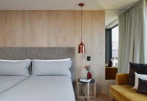 a bedroom with a white bed and a couch at ME by Meliá Barcelona in Barcelona