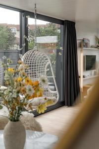 a vase of flowers in a room with a window at B&B Armalot by Julia in De Panne