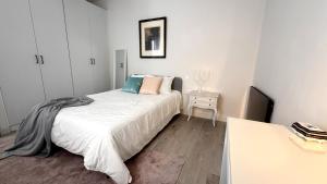 a white bedroom with a bed and a table at Posadas de María Casa María 3 in Talavera de la Reina