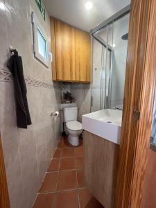 a bathroom with a white sink and a toilet at La Casita de Sara in Cercedilla +7 photos