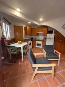 a kitchen with a table and two chairs and a table and a tablektop at La Casita de Sara in Cercedilla