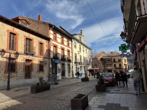 a city street with buildings and people walking down a street at La Casita de Sara in Cercedilla