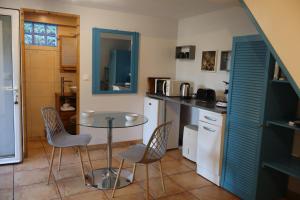 a kitchen with a table and chairs in a room at Ti Kaz Ravinala in Ravine des Cabris +7 photos