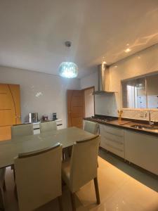 a kitchen with a table and chairs in a kitchen at Royal Lion Bedroom in Londrina