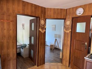 a room with two doors and a clock on the wall at Bokaczówka in Ustka